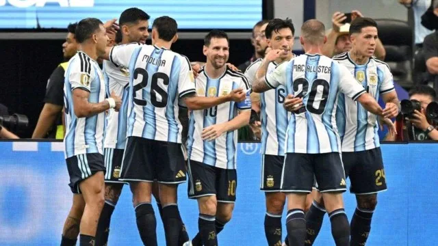 Hinchas argentinos con camiseta de la Selección celebrando en un estadio de fútbol