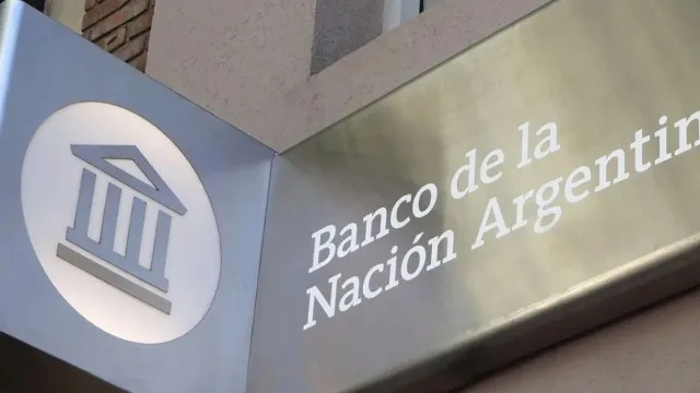 Billetes de pesos argentinos junto a un dólar y calculadora financiera