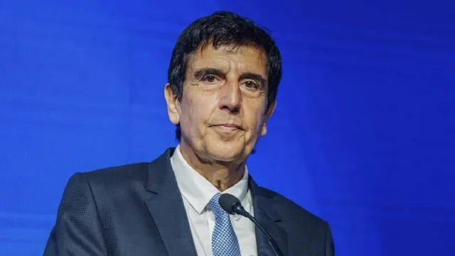 Carlos Melconian hablando en un evento económico con micrófono y expresión seria